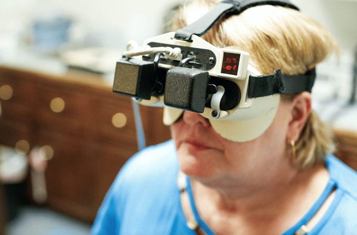 A female patient during wearing a head gadget during balance disorder test at Acadian Hearing